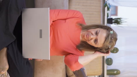 Vertical-video-of-Woman-looking-at-laptop-is-thoughtful.